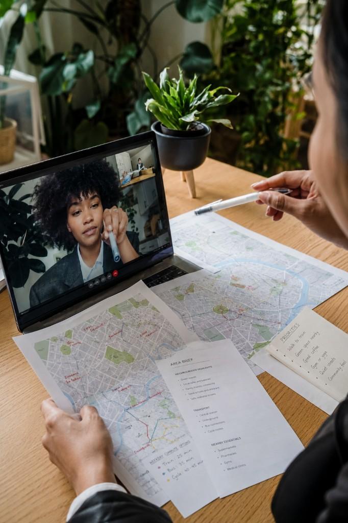 A person reviewing an area brief and neighbourhood map during a Virtual Orientation session on a laptop.